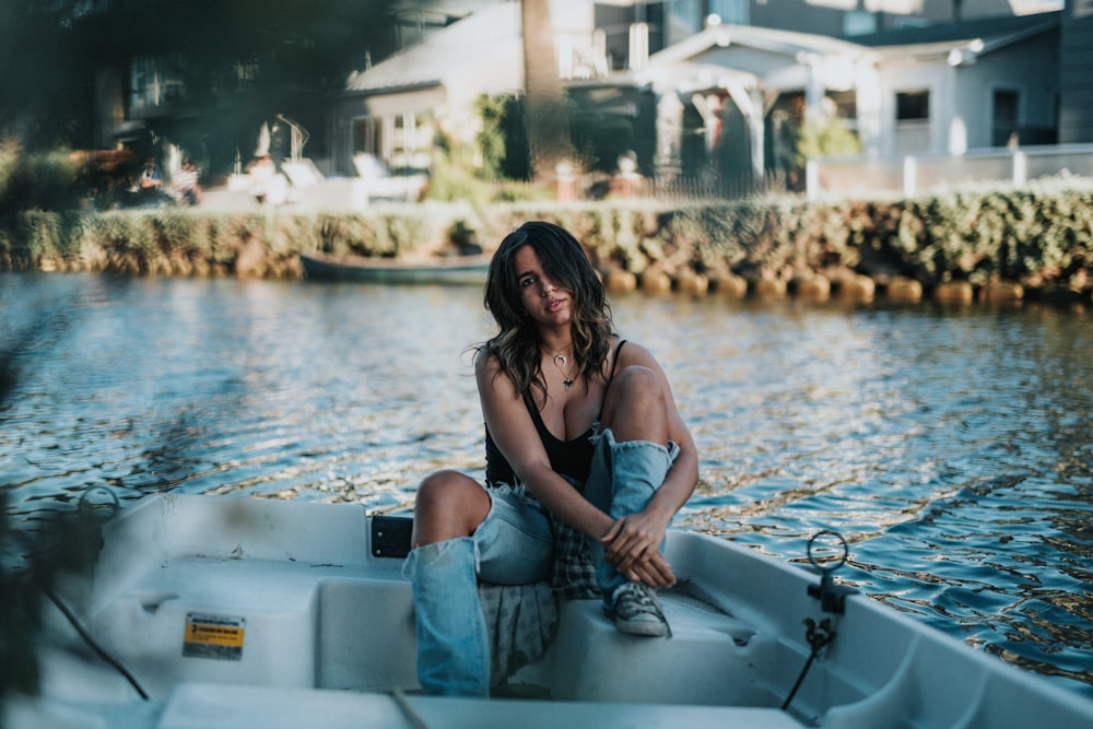 donna che si siede sulla barca sullo specchio d'acqua