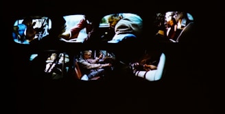 Multiple car interiors are visible, each showing different people engaged in various activities, including driving and handling objects. The scene appears dynamic and action-oriented.