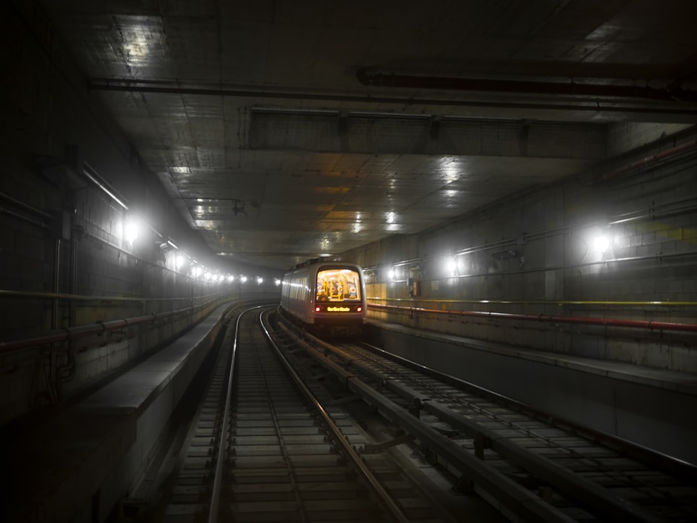 white and black speed train in tunnel