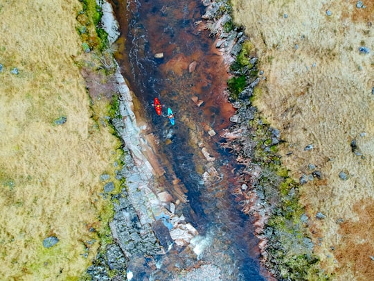 aerial photography of two person's riding on kayak on river at daytime in Glen Etive United Kingdom