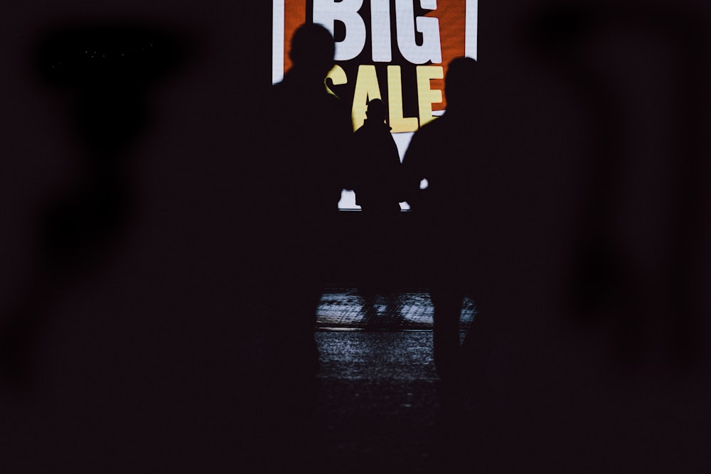 Un hombre parado frente a un gran cartel