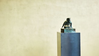 A bronze sculpture casting displayed on a wooden pedestal.