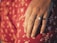 Close-up of a hand wearing a luxurious diamond ring on a velvet background.
