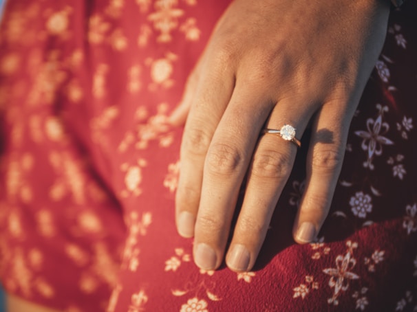A close-up of a sparkling engagement ring on a velvet cushion.