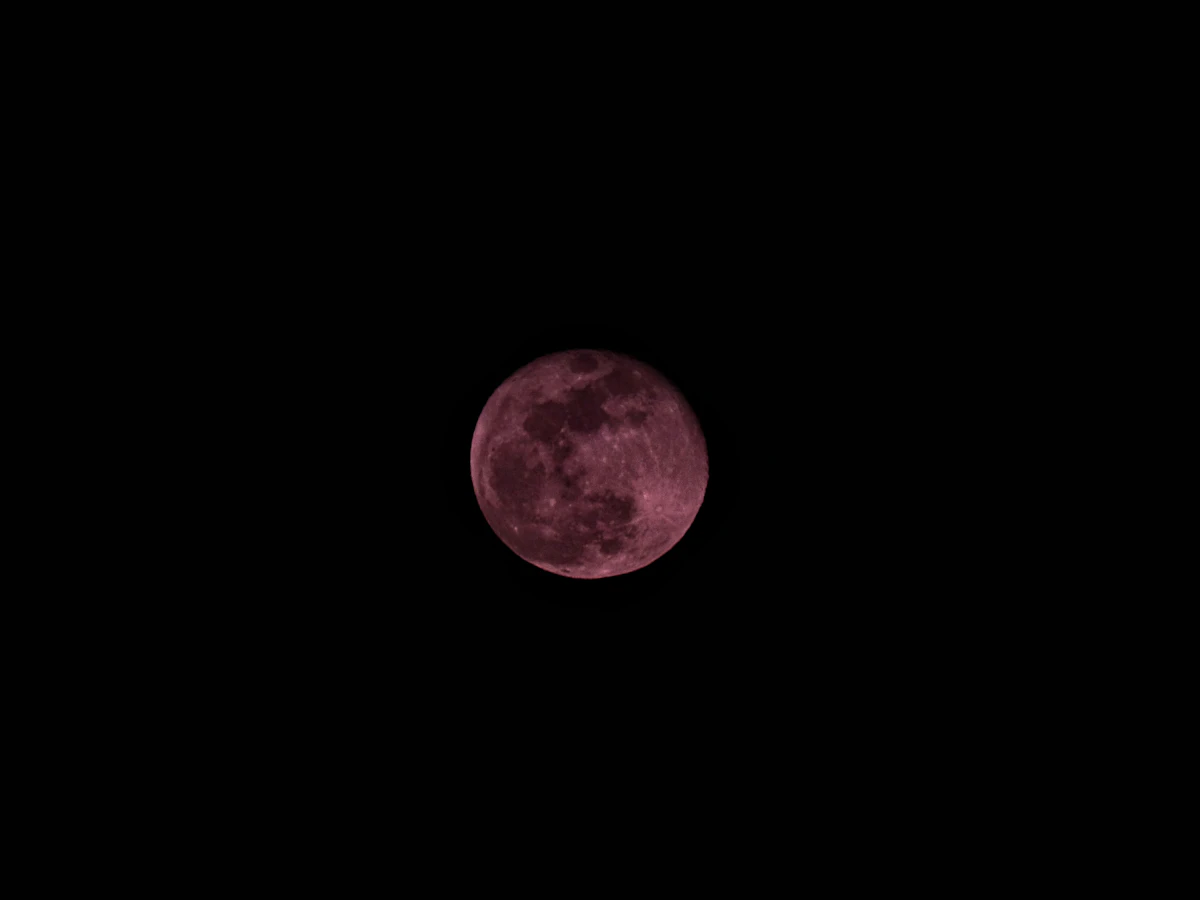 A red-tinted moon in dark sky