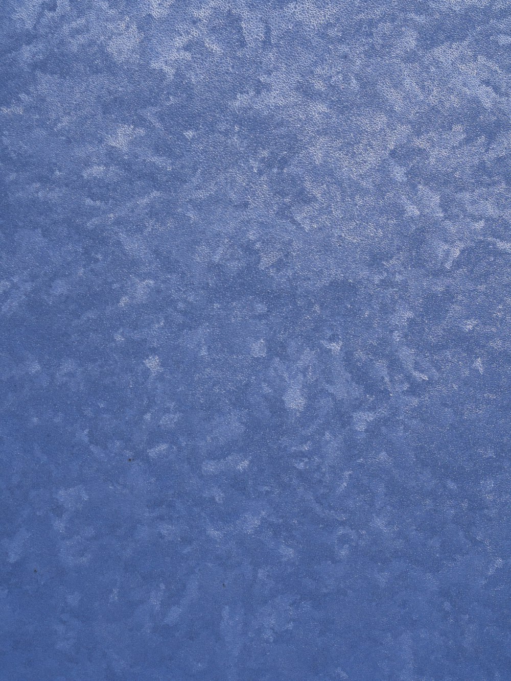 an airplane is flying over a blue surface