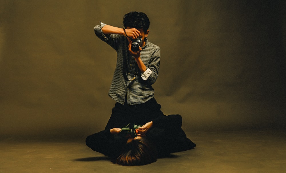 man holding camera taken photo of person holding camera lying down on floor