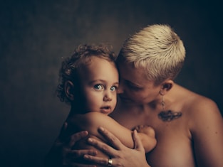 topless woman holding baby