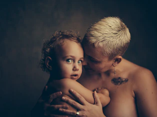 topless woman holding baby