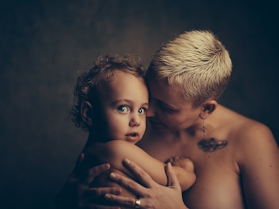 topless woman holding baby