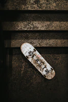 Close-up of a worn skateboard deck with Baja-inspired street art.