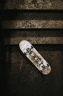 Close-up of a worn skateboard deck with Baja-inspired street art.