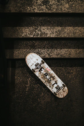 Close-up of a worn skateboard deck with Baja-inspired street art.