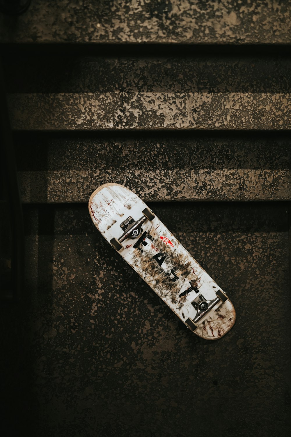 weißes Skateboard neben Treppe