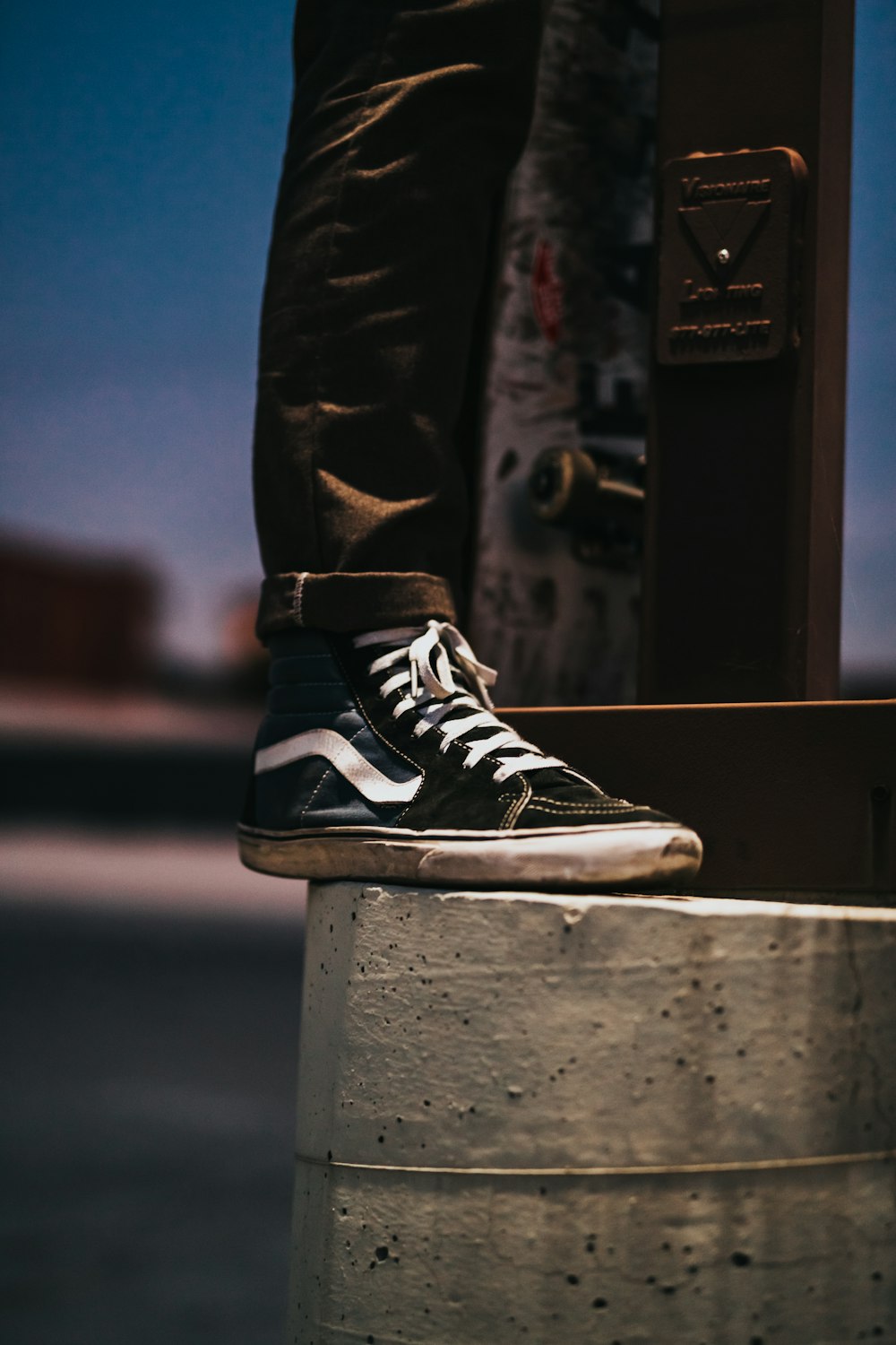 person stepping on edge of concrete pillar