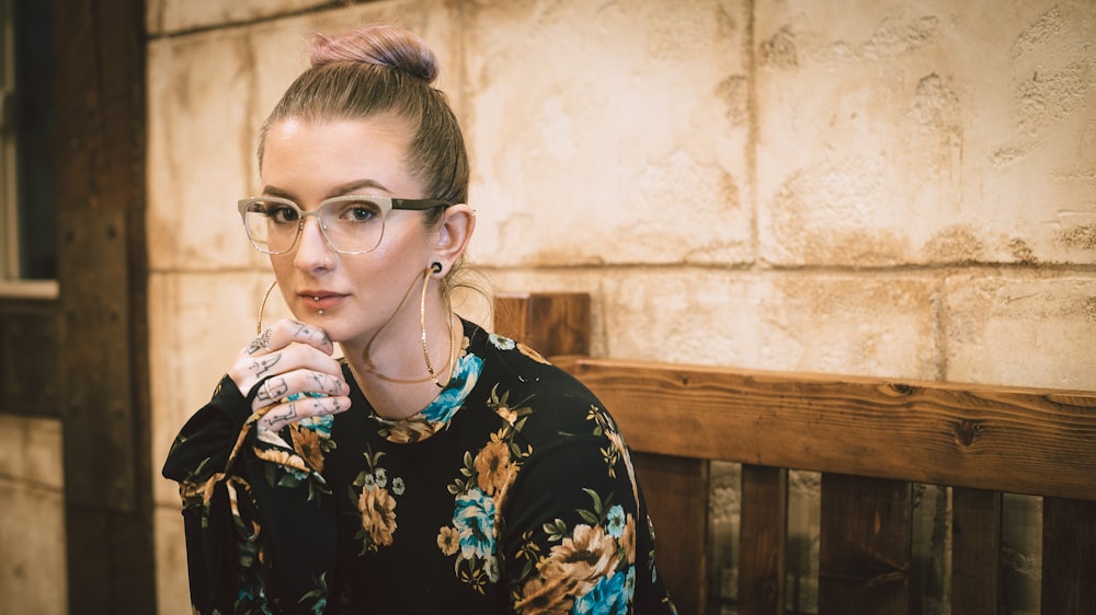 woman holding her chin sitting on bench