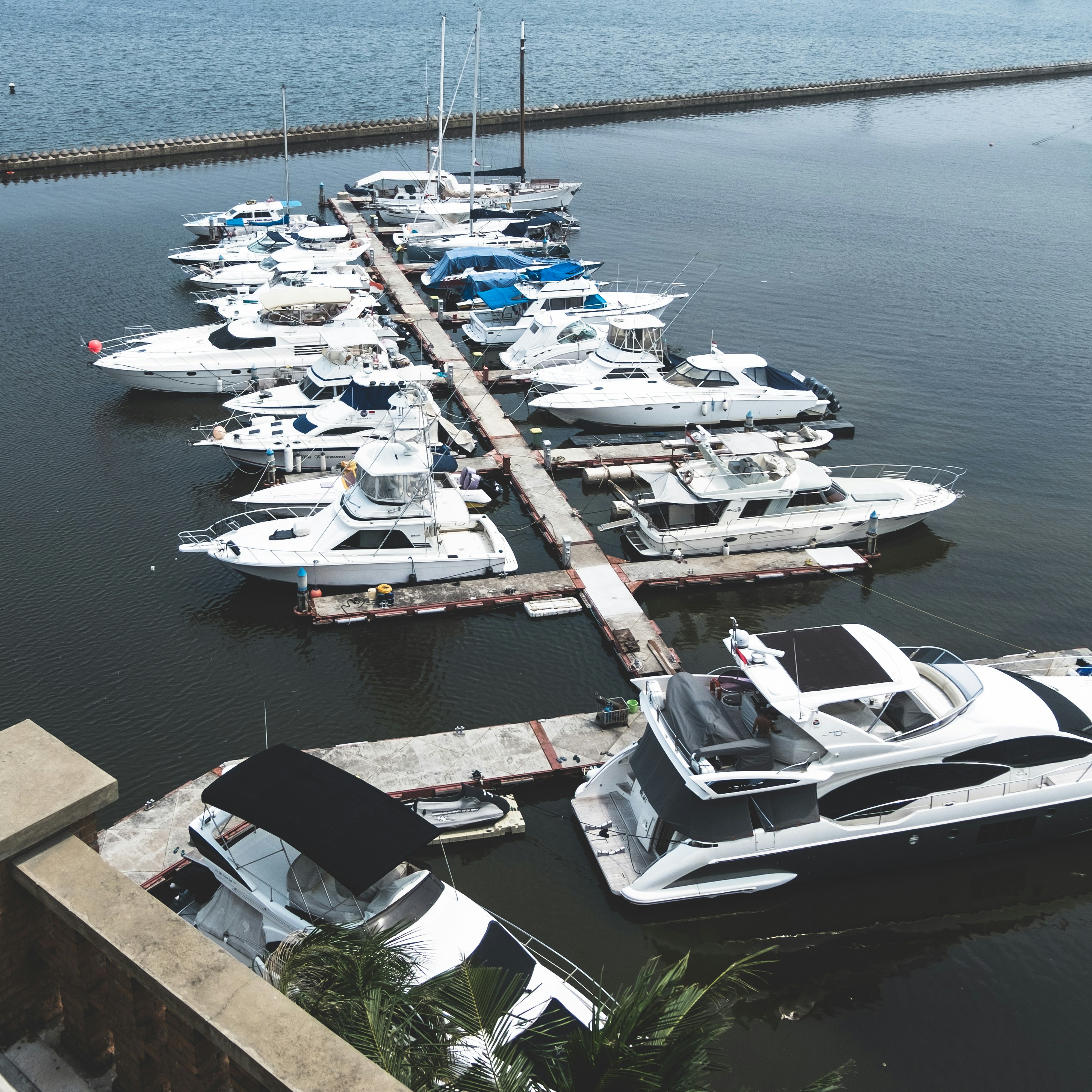Charter fishing yacht moored at a sunny marina with clear water below