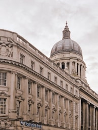 architectural photography of gray concrete structure under cloudy sky