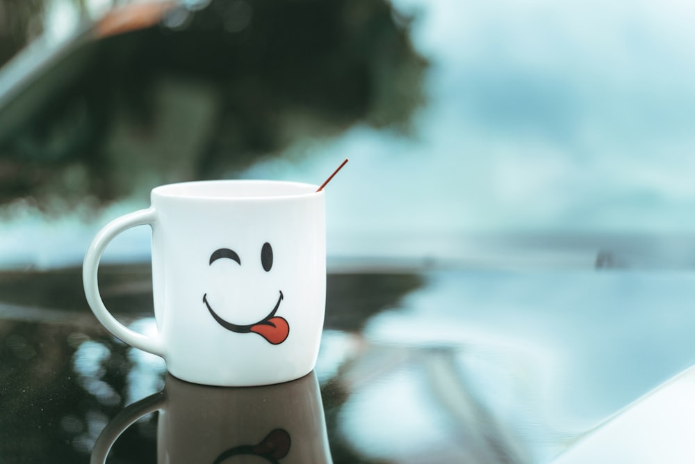 a coffee cup with a smiley face painted on it