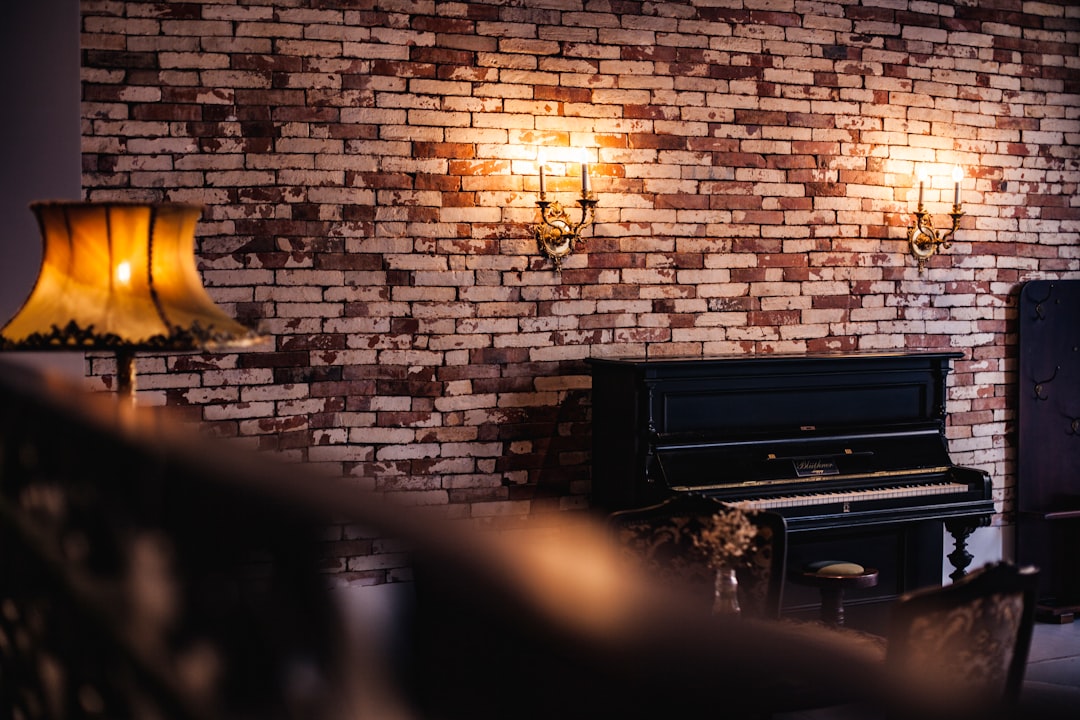 black upright piano near brown lampshade