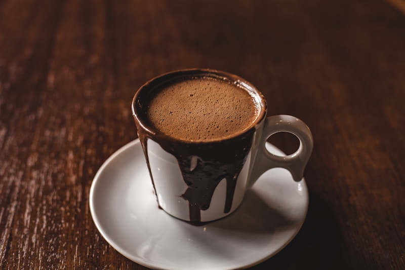 Cup of spiced coffee with foam on a wooden table