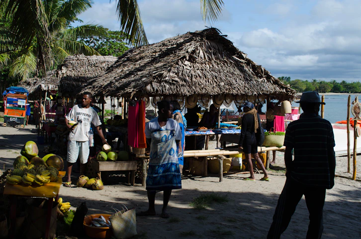 A lively market scene in a Caribbean port with local crafts and fresh fruit stands.