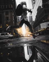 person jumping above puddle of water