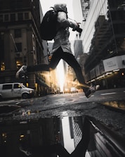 person jumping above puddle of water