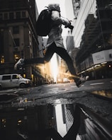person jumping above puddle of water