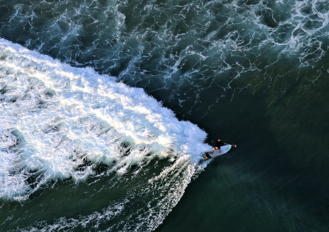 top view photography of man beside surfboard