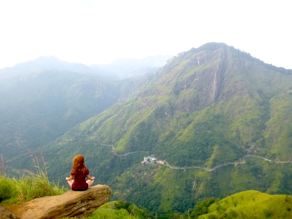 woman sitting on brown rock