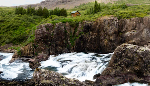 A cozy glamping cabin terrace overlooking the lush green canyon and river below.
