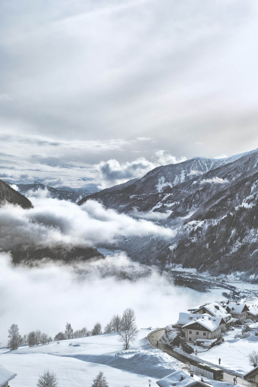 snow-covered village near mountains under white clouds during daytime