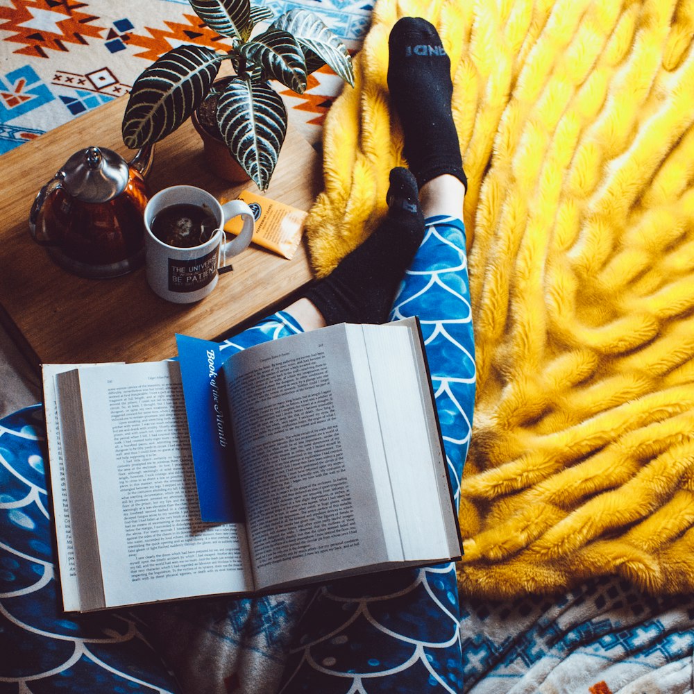 book opened on person's legs