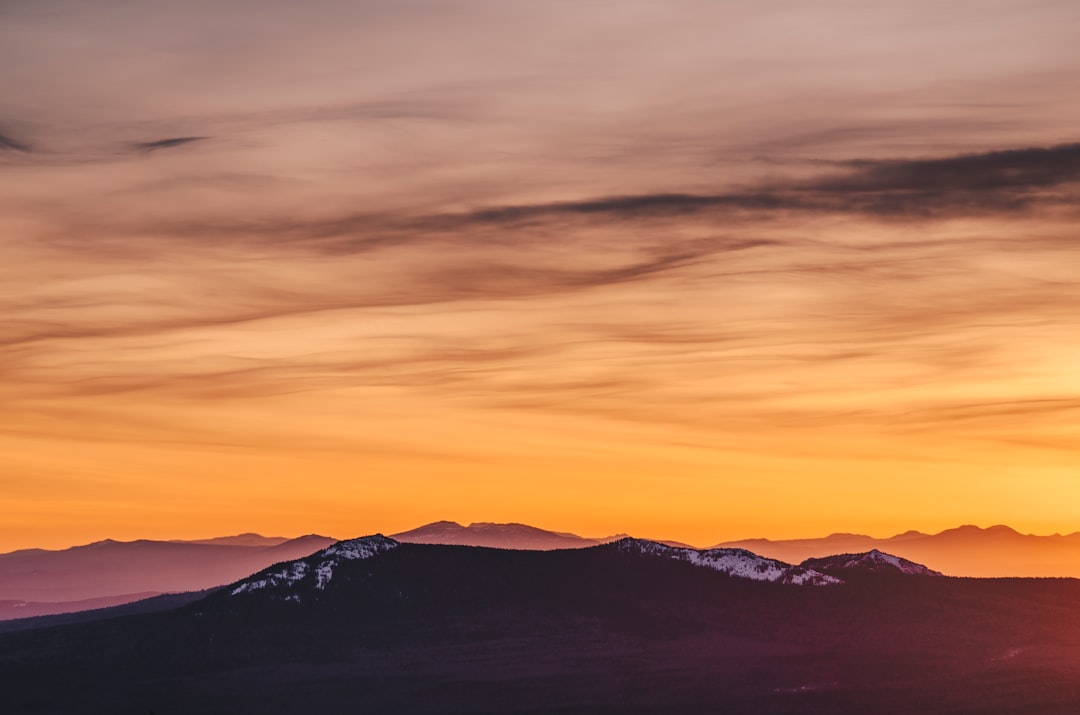 silhouette of mountain during yellow cloudy skies