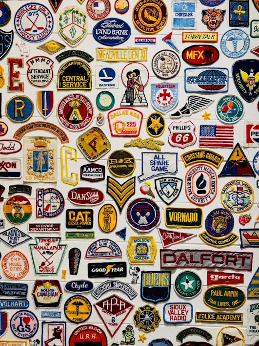 Close-up of colorful embroidered patches arranged on a wooden table.