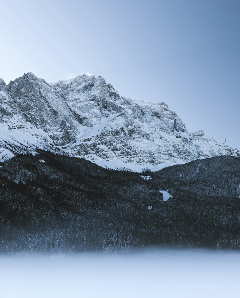 snow-covered mountain near trees under blue clear sky during daytime