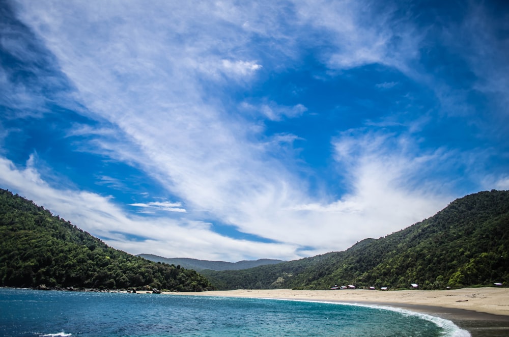 mar rodeado de montañas bajo el cielo azul