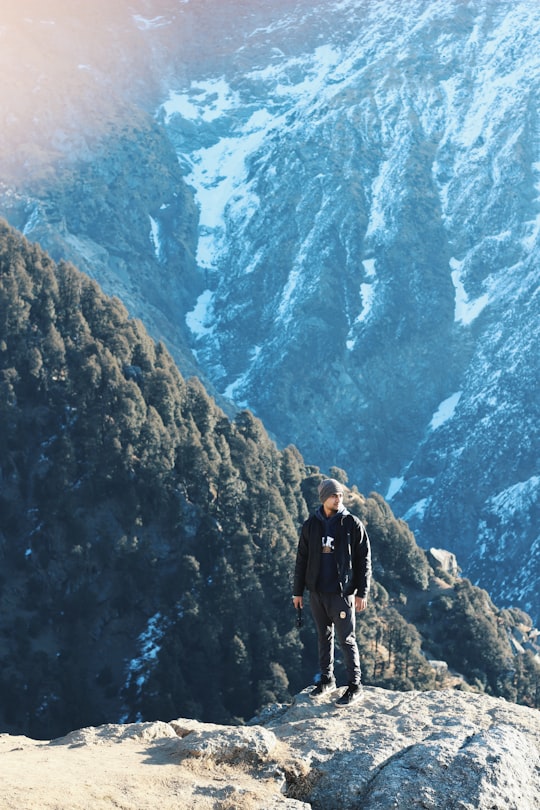 person standing on the rock in Triund India