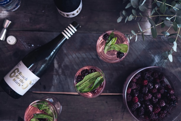 A rustic wooden table with a bottle of Pobre Juan wine and two glasses ready to be shared.