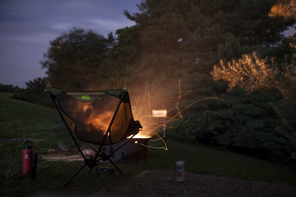 camper chair beside firepit beside trees
