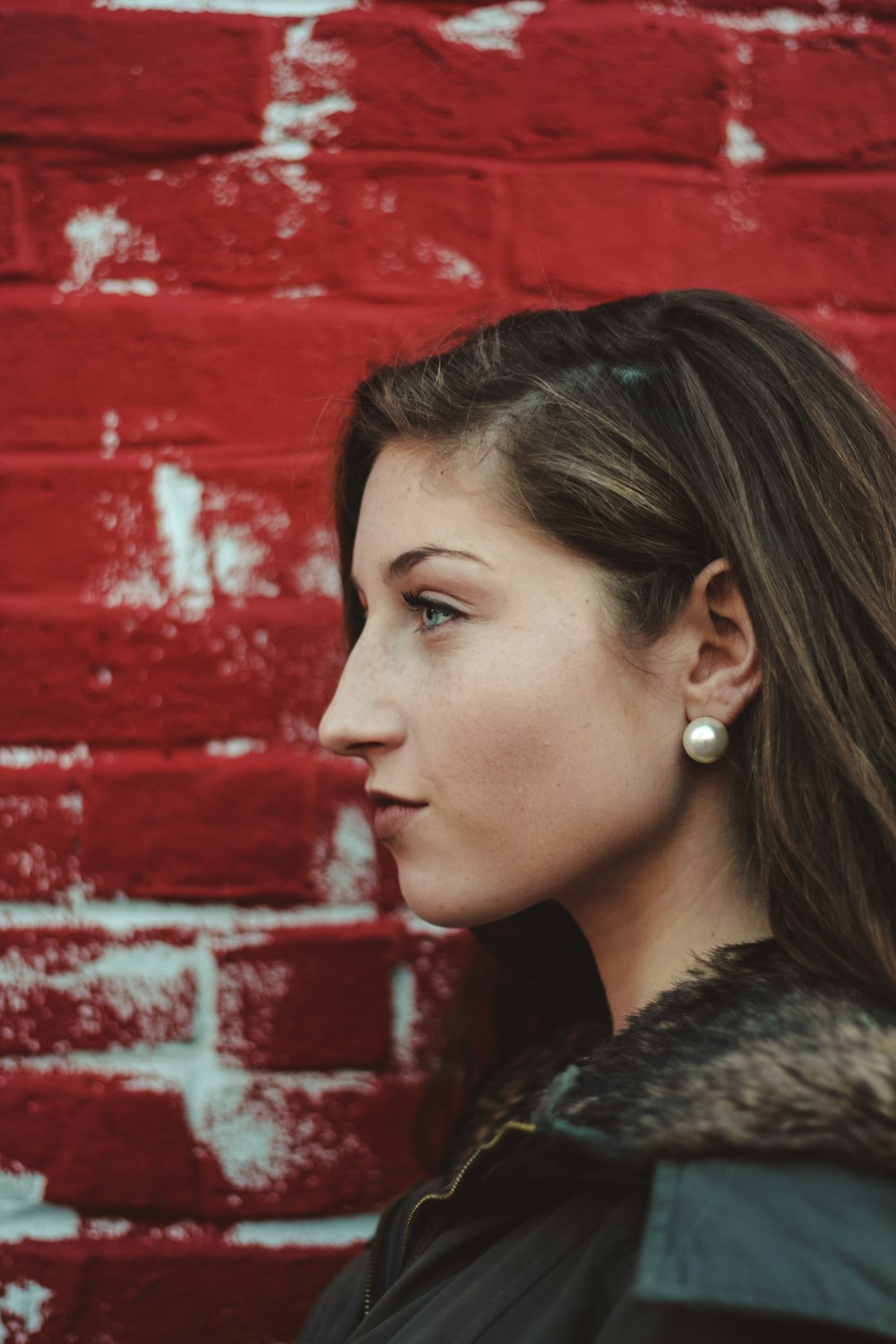 closeup photo of woman beside red painted wall