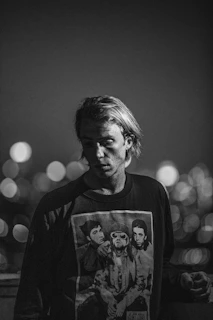 A cozy black and white photo of a model wearing a soft oversized cotton combed 24s t-shirt in a casual 90s style setting.