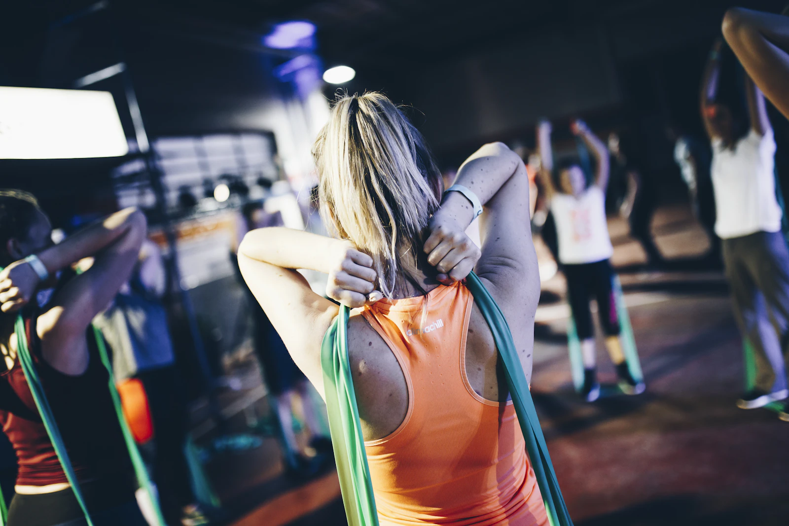 Athlete holding a green resistance band behind the back during an exercise