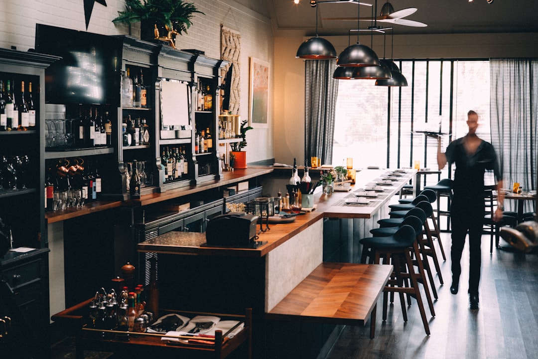 person standing beside bar holding tray