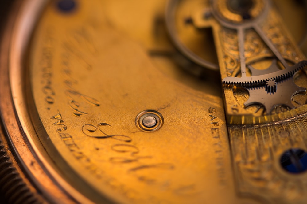a close up of a gold pocket watch