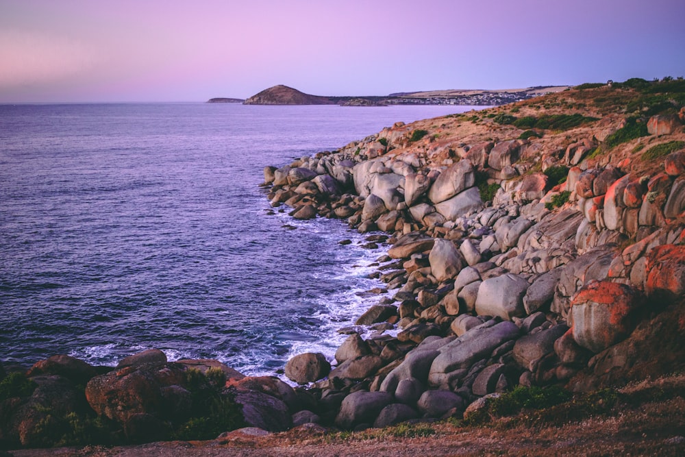 landscape photography of rock formations near body of water