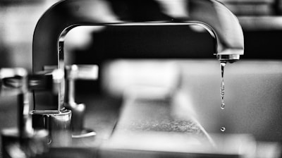 grayscale photography of faucet