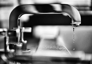 grayscale photography of faucet