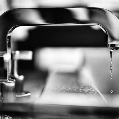 grayscale photography of faucet